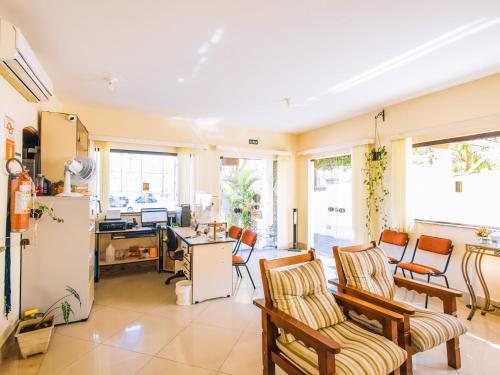 een woonkamer met een koelkast en een tafel en stoelen bij VELINN Pousada Mirante da Praia Grande in Ilhabela