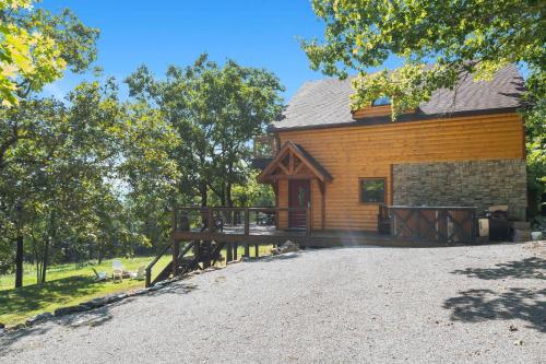 a log cabin with a porch and a driveway at Ozark Outdoor Legacy in Ridgedale