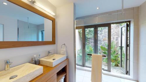 a bathroom with a sink and a mirror at Villas de Vacances à Pereybère V8 in Pereybere