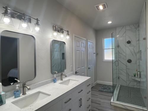 uma casa de banho branca com 2 lavatórios e um chuveiro em Luxury Ranch Retreat With Swimming Pool em Anna