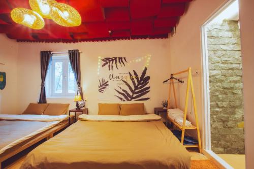 a bedroom with two beds and red ceilings at De Vivre Homestay Măng Đen in Kon Von Kla