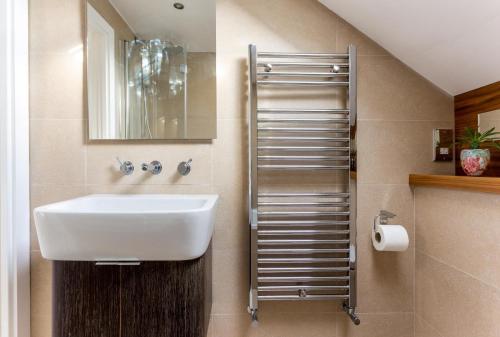 La salle de bains est pourvue d'un lavabo et d'un miroir. dans l'établissement Elephant & Oxpecker in Fulham, à Londres