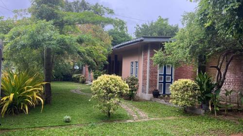 a brick house with a yard in front of it at Honey Tree Polonnaruwa in Polonnaruwa