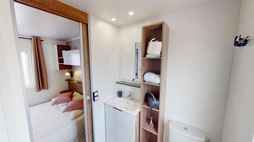 Baño pequeño con lavabo y espejo en Mobil home Cygne 85 en Quiberon