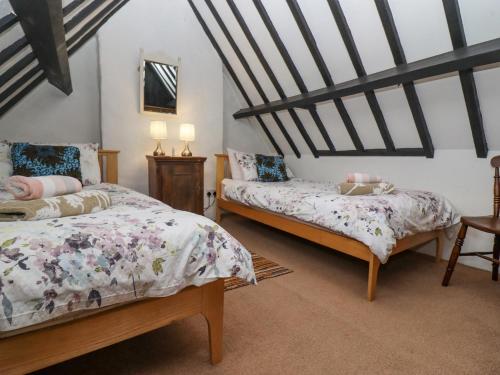 Un dormitorio con dos camas en un ático. en Newbury Cottage, en Bourton on the Water