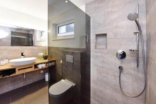 ein Bad mit einer Dusche, einem WC und einem Waschbecken in der Unterkunft Ferienwohnung Saxenhammer in Vandans