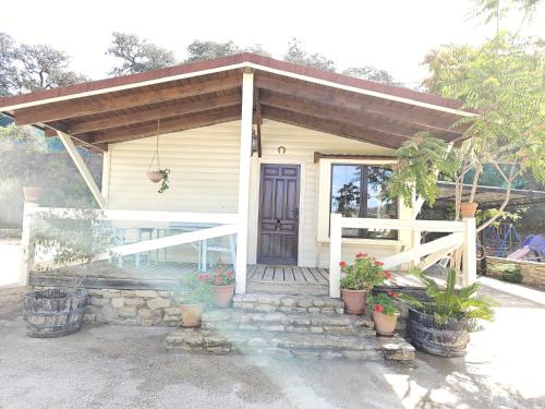 a small white house with a wooden door at La casita de madera Sijuela in Ronda