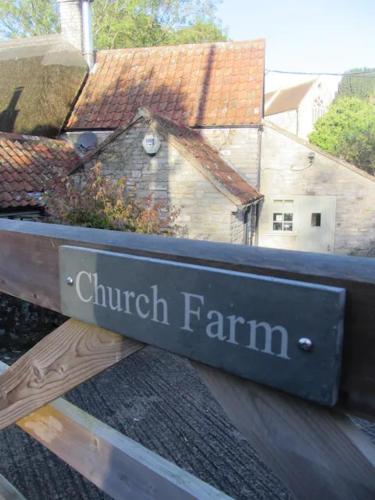a sign for a church farm on the side of a building at The Garden Room in Dundon