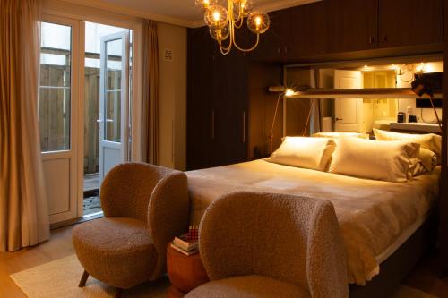 een slaapkamer met een groot bed en 2 stoelen bij B&B Midtown Amsterdam suites in Amsterdam