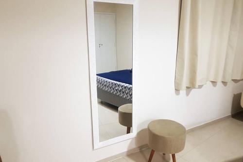 a mirror in a room with a chair and a bed at Studio 1811 Campinas SP in Campinas