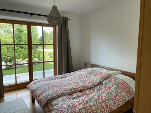 1 dormitorio con cama y ventana grande en Fembacher Alm, en Seeon-Seebruck