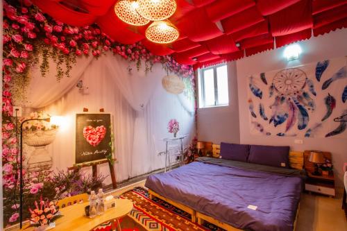 a bedroom with a bed in a room with flowers at De Vivre Homestay Măng Đen in Kon Von Kla