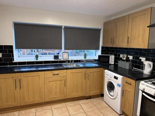 a kitchen with a sink and a dishwasher at Haven 1 in Thamesmead