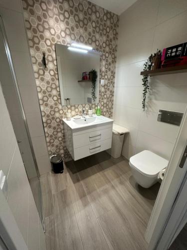 a bathroom with a sink and a toilet and a mirror at Ascensor à Vista in Nazaré