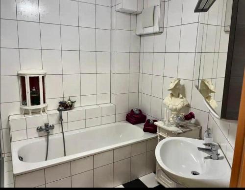 ein weißes Badezimmer mit einer Badewanne und einem Waschbecken in der Unterkunft Vintage Traum in Hückelhoven