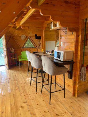 a kitchen with a table with chairs and a microwave at Las Nubes Domo in La Mesa
