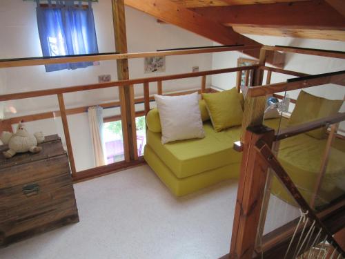 un salon avec un canapé vert et une fenêtre dans l'établissement La Cabane Bleue, à Salles-sur-Mer