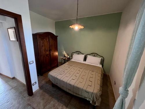 a bedroom with a bed and a green wall at Agriturismo Serre in SantʼAgata di Militello