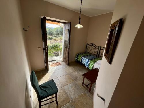 a room with a bedroom with a bed and a window at Agriturismo Serre in SantʼAgata di Militello