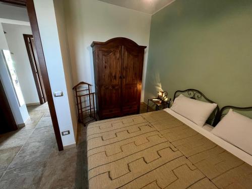 a bedroom with a large bed with a wooden headboard at Agriturismo Serre in SantʼAgata di Militello