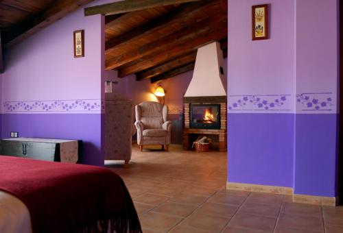 a bedroom with purple walls and a fireplace at La Posada De Santa Ana in Tramacastilla