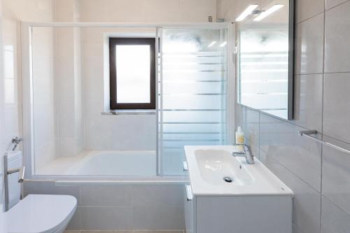 W łazience znajduje się wanna, umywalka i prysznic. w obiekcie Modern 3 bedrooms 3 bath apartment 5 minutes walk from the Santuary w Fatimie