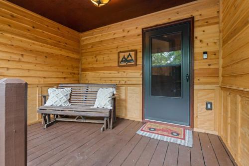 a wooden porch with a bench and a door at Bit A Trees in Blairsville