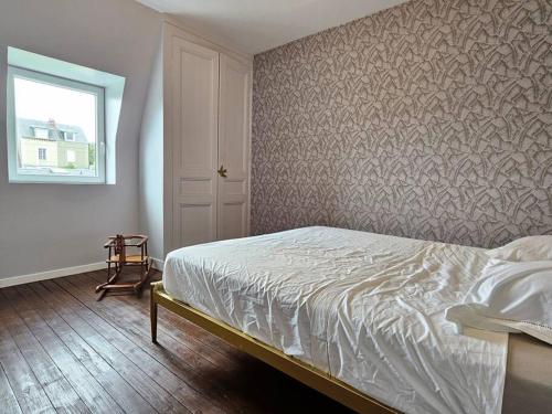 Un dormitorio con una cama blanca y una ventana. en Maison familiale, 3 chambres, jardin, au calme, en Trouville-sur-Mer