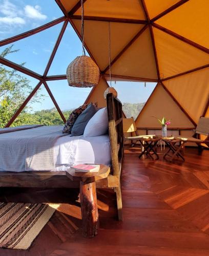 a bedroom in a tent with a bed and tables at Glamping - Habla con la Luna in Santa Marta