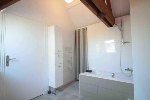 a white bathroom with a tub and a sink at La Pidellerie bord de Cher-Châteaux de la Loire in Véretz