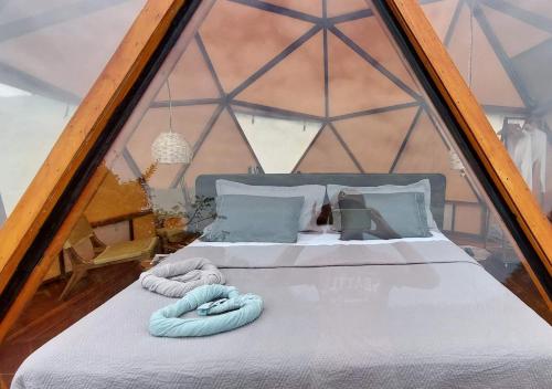 a bed in a tent with two towels on it at Glamping - Habla con la Luna in Santa Marta