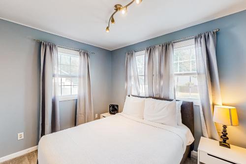 a bedroom with a bed and two windows at Neverending Beauty in Glens Falls