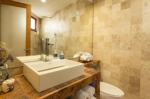 a bathroom with a white sink and a toilet at Casa La Columna in Puerto Vallarta