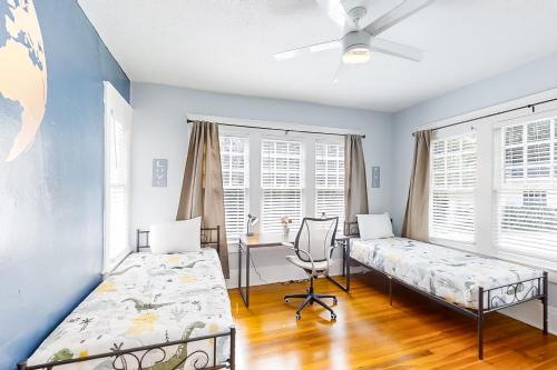 a bedroom with two beds and a desk and windows at Sydney Spring Garden in Jacksonville