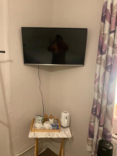 einen Flachbild-TV, der an einer Wand hängt in der Unterkunft One Double bedroom in a Shared apartment in London