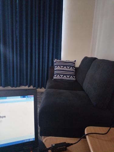 a living room with a couch and a laptop computer at Executive 1&2 Broom Airbnb in Gilgil Nakuru in Gilgil