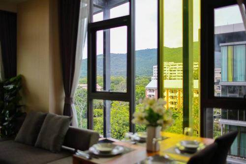 a dining room table with a view of a city from a window at Stunning Spacious Mountain View Apartment in Chiang Mai