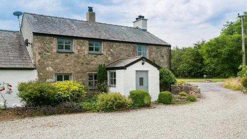 an old stone house with a gravel driveway at Brithdir Mawr in Bangor