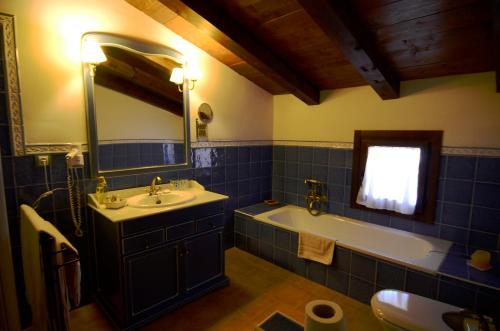 a bathroom with a sink and a tub and a mirror at La Posada De Santa Ana in Tramacastilla