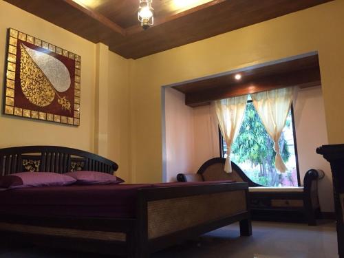 a bedroom with a bed and a window at Sweet Inn Resort in Bang Pahan