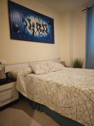 um quarto com uma cama e um quadro na parede em Edificio Mondrian 1ª Linea vistas al mar em Oropesa del Mar