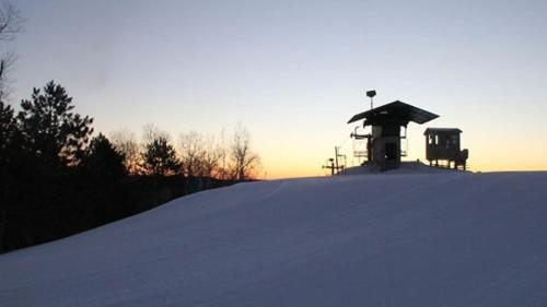 a snow covered hill with a building on top of it at Seven Springs 2BRLoft Premium Condo, sleeps 11! condo in Champion