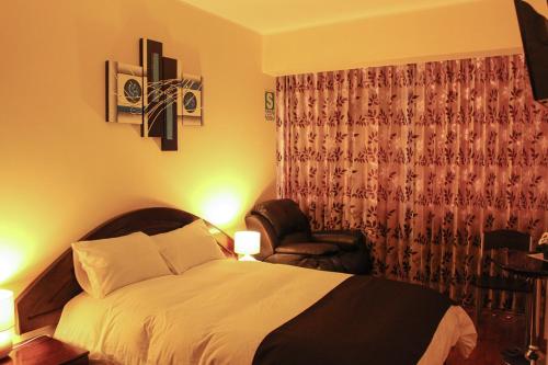 a hotel room with a bed and a chair at Hotel B&V in Huancayo