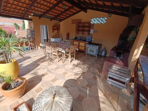 een patio met een tafel en stoelen en een keuken bij Chácara Rotha de Piri in Pirenópolis