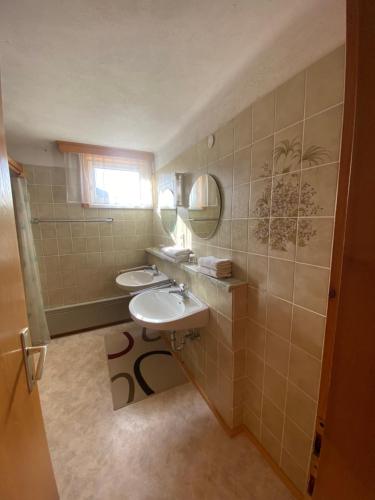 a bathroom with two sinks and a mirror at Bauernhof Helpferer in Ramsau am Dachstein