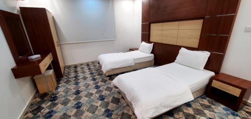 a small room with two beds in it at فندق قصر اباهي 3 in Buqayq