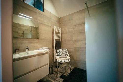 baño con lavabo y silla en Les Pinsons en Montigny-le-Gannelon