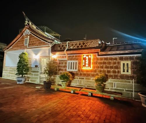 Una casa de ladrillo con un cartel en ella por la noche en 時光旅舍古厝一館, en Jinning