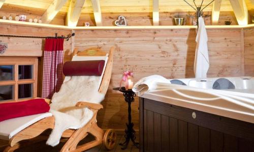 a bathroom with a tub and a rocking chair next to a bath tub at Chalet Schönbuchet in Mauth