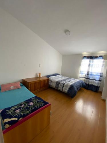 a bedroom with two beds and a wooden floor at AlejandraPacheco in Federación